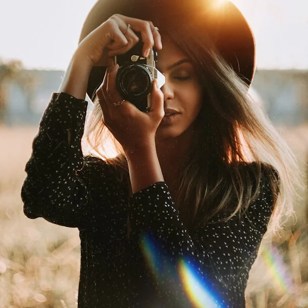 Woman holding a camera outdoors